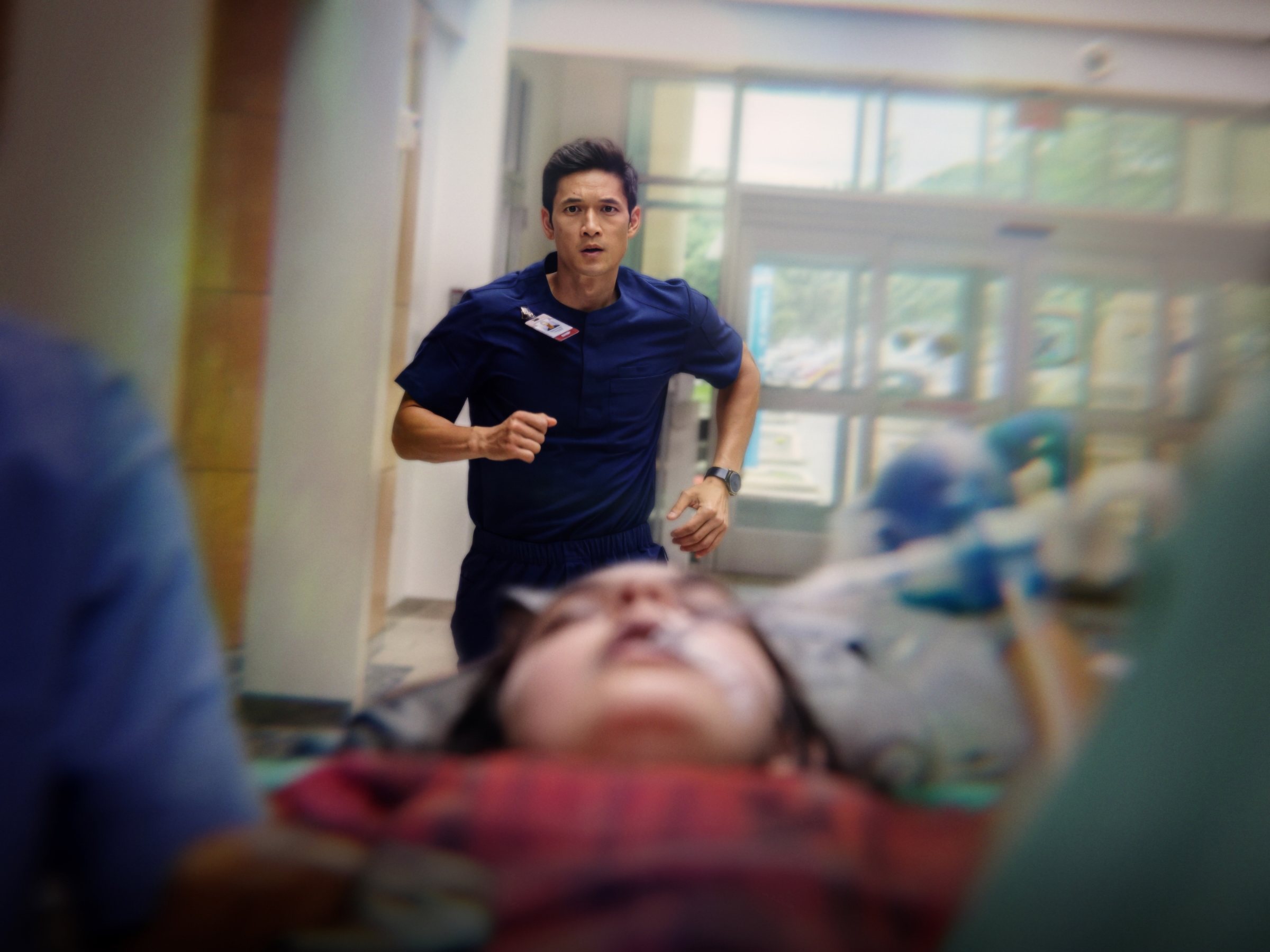 Sam Yeong running a patient down a hospital corridor